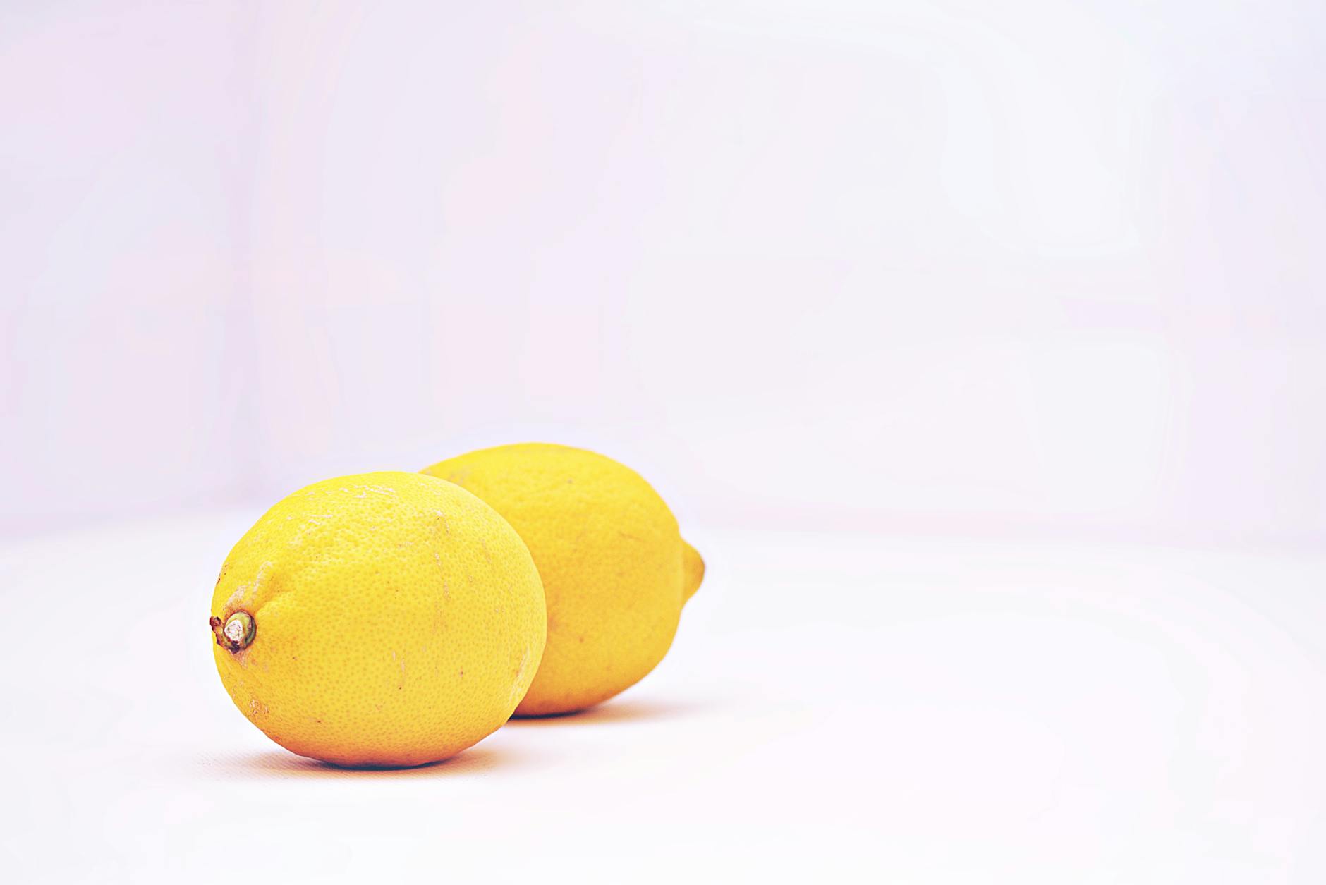 Two bright lemons on a white background, representing freshness and renewal