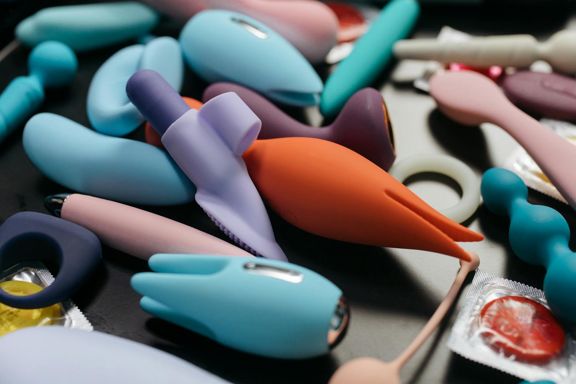A blue silicone clitoral vibrator held in hand, symbolizing reconnection to bodily pleasure and intimate wellness.