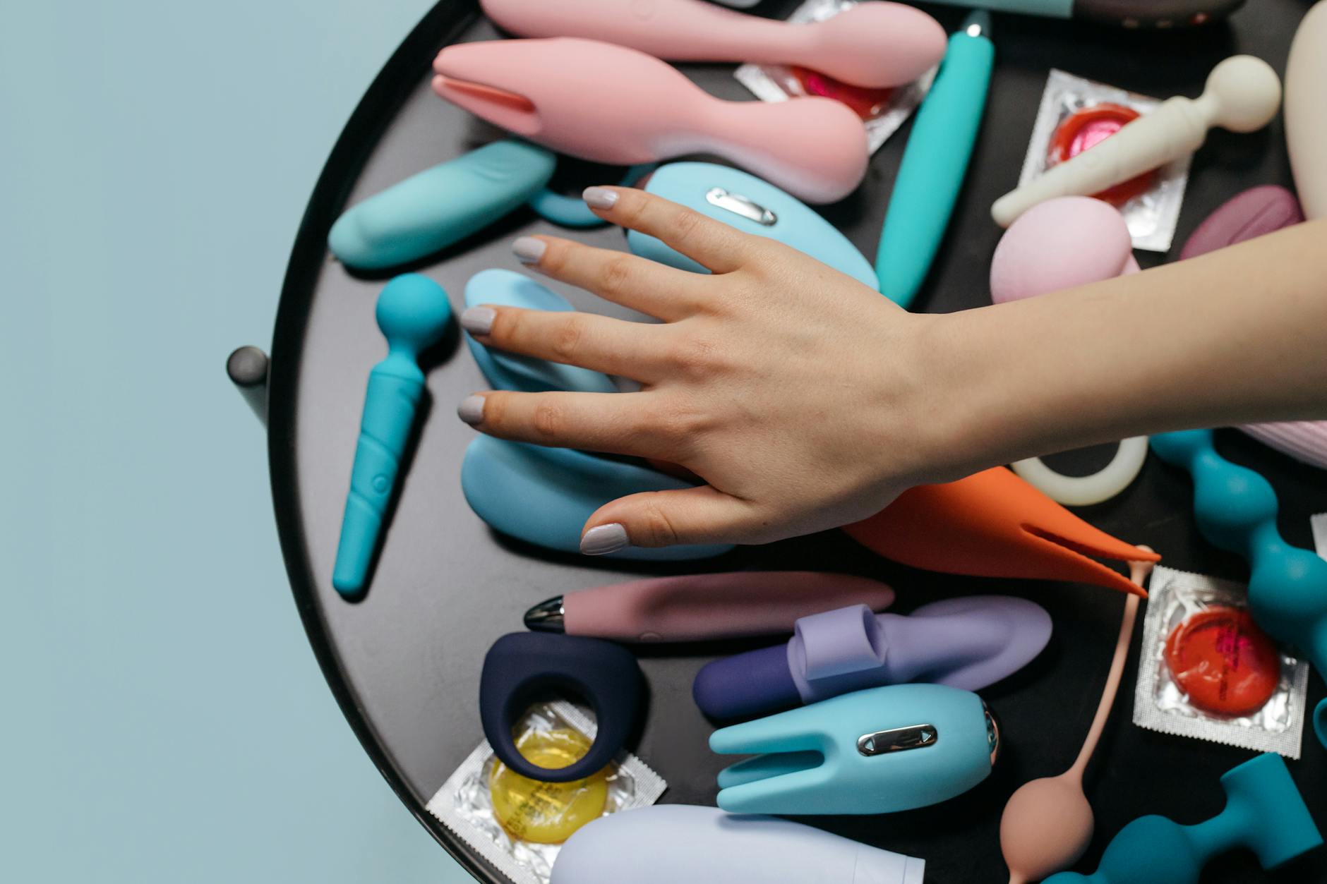 A blue silicone sex toy held in hand against a purple background, symbolizing self-love and rekindled pleasure.