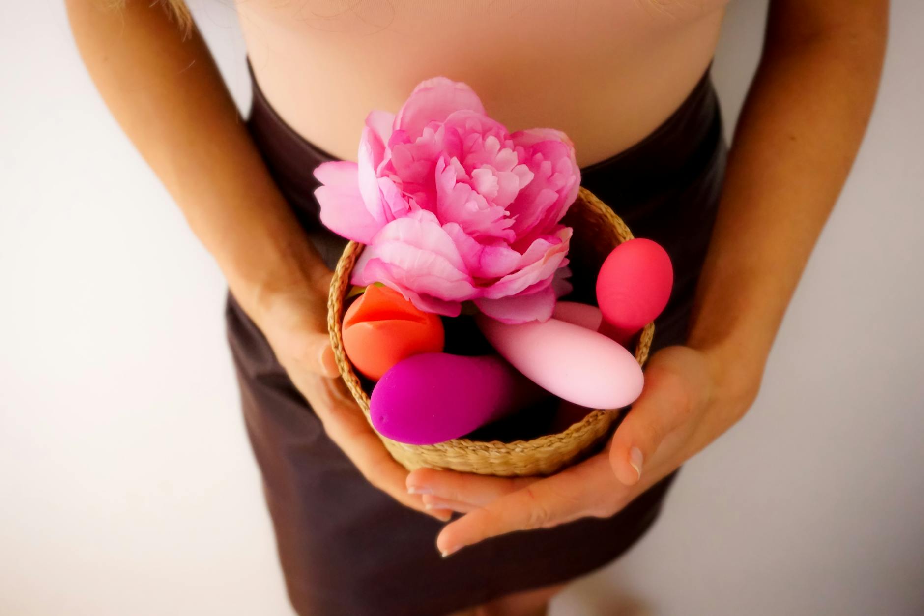 A basket of colorful vibrators and intimate wellness products displayed together