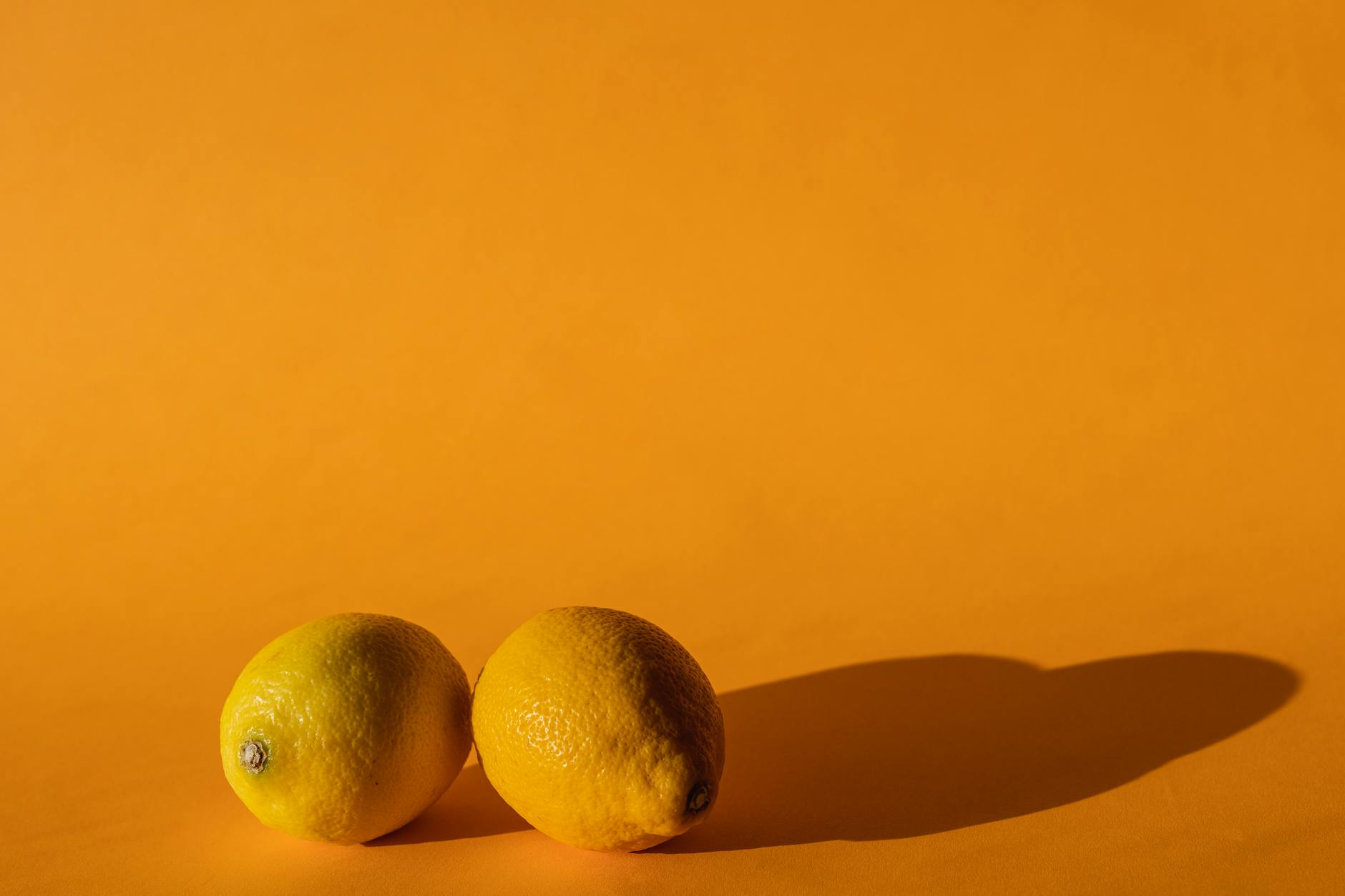 Ripe vivid lemons on bright yellow background symbolizing freshness and renewal